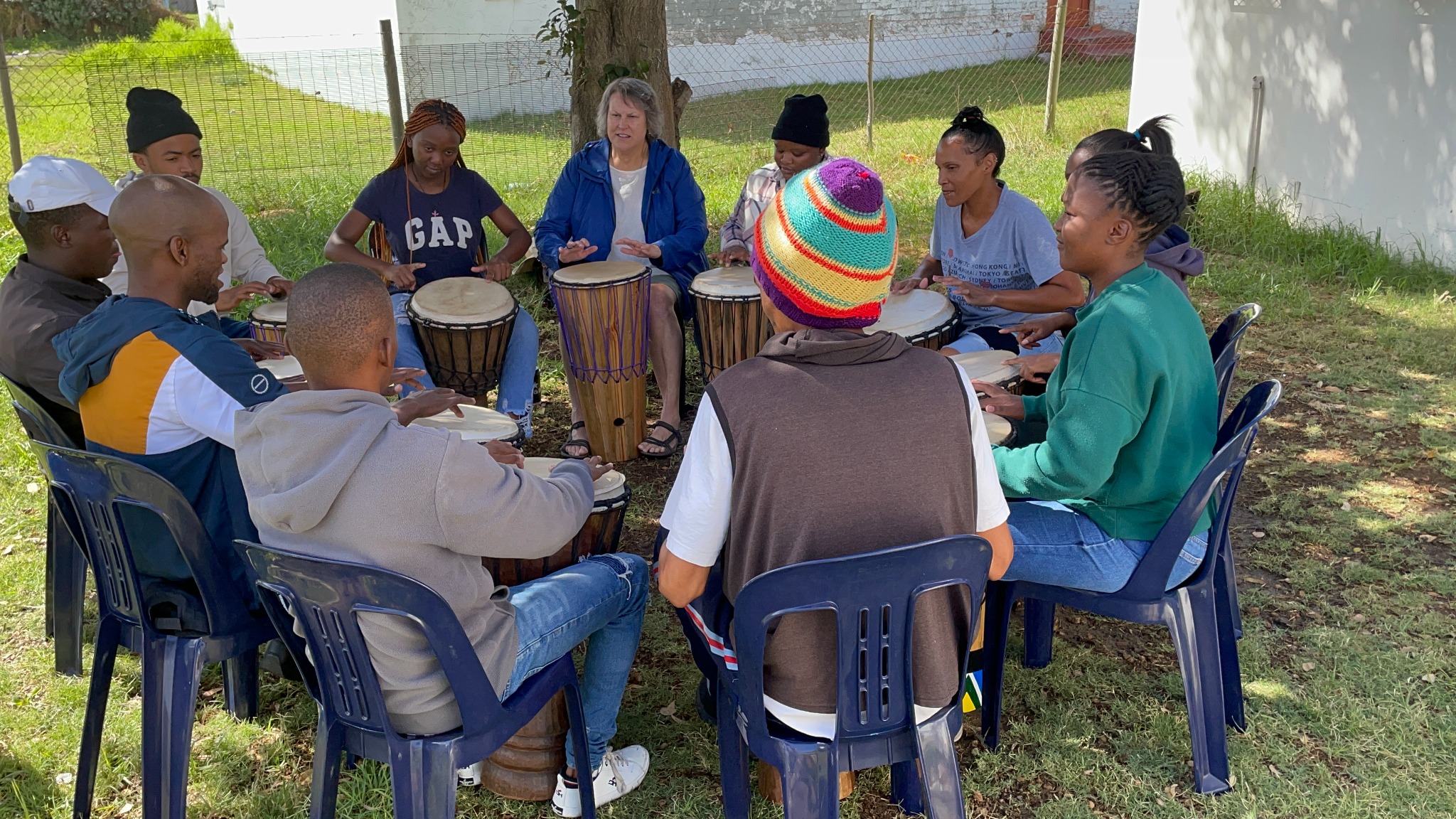 Young adults gathered in a drumming circle in South Africa